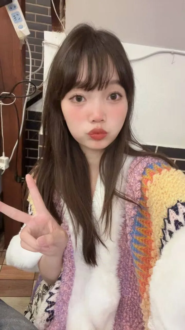 女孩对着镜头比剪刀手