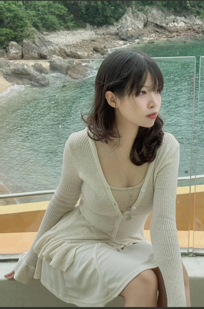 女孩坐在海边栏杆