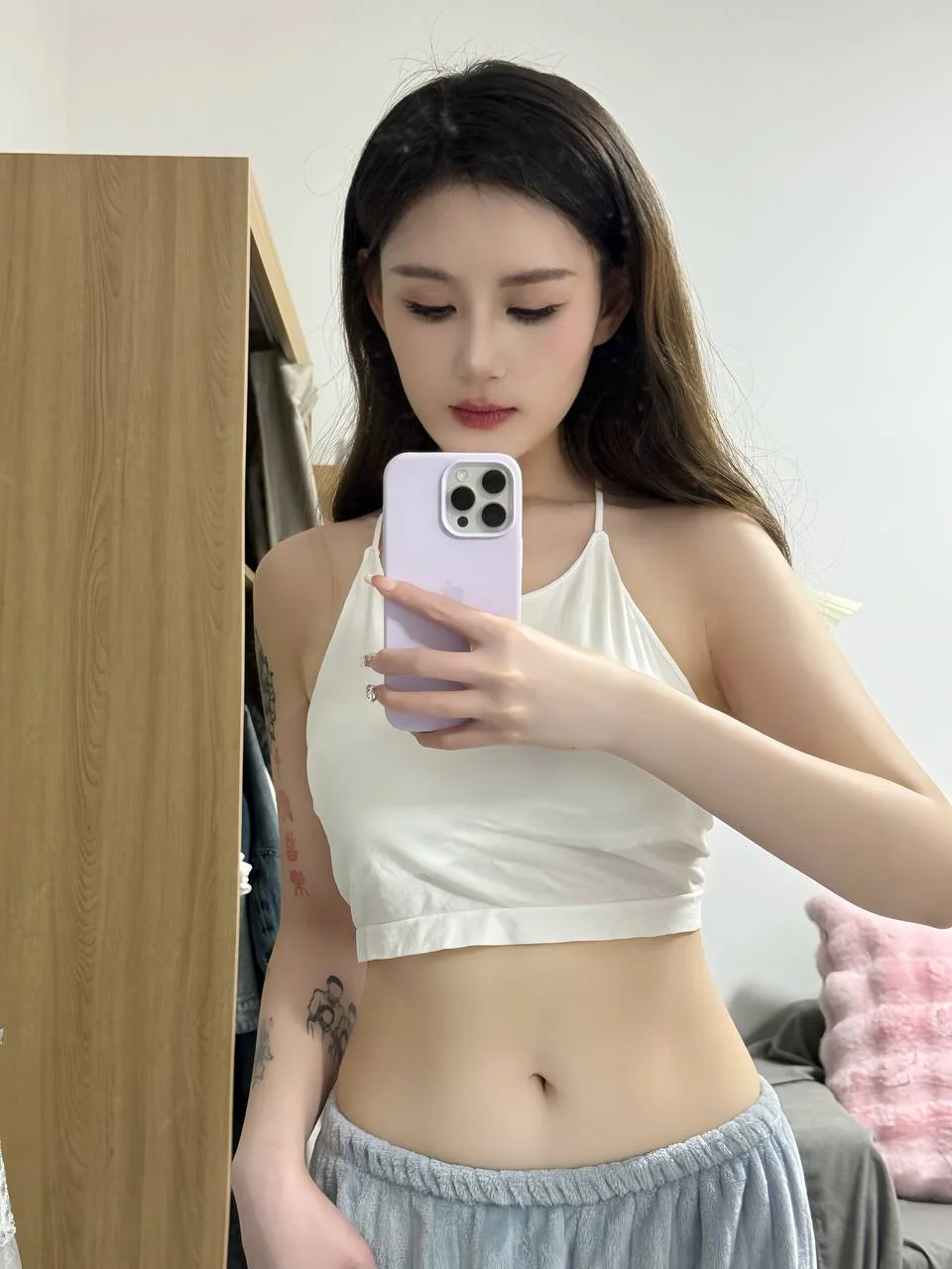 长发女孩举紫色手机自拍露腰