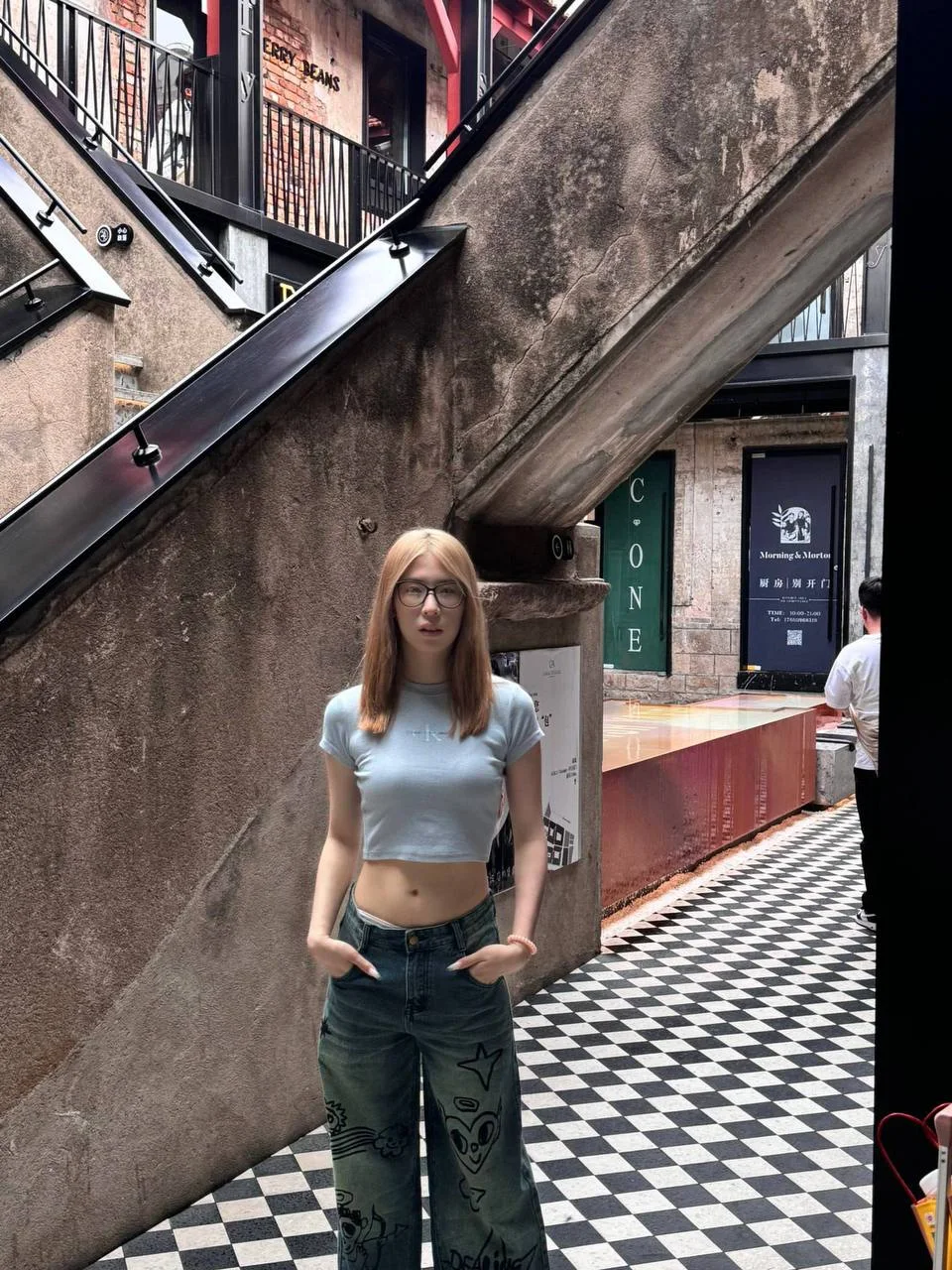 眼镜女孩双手插兜站在黑白格地板上