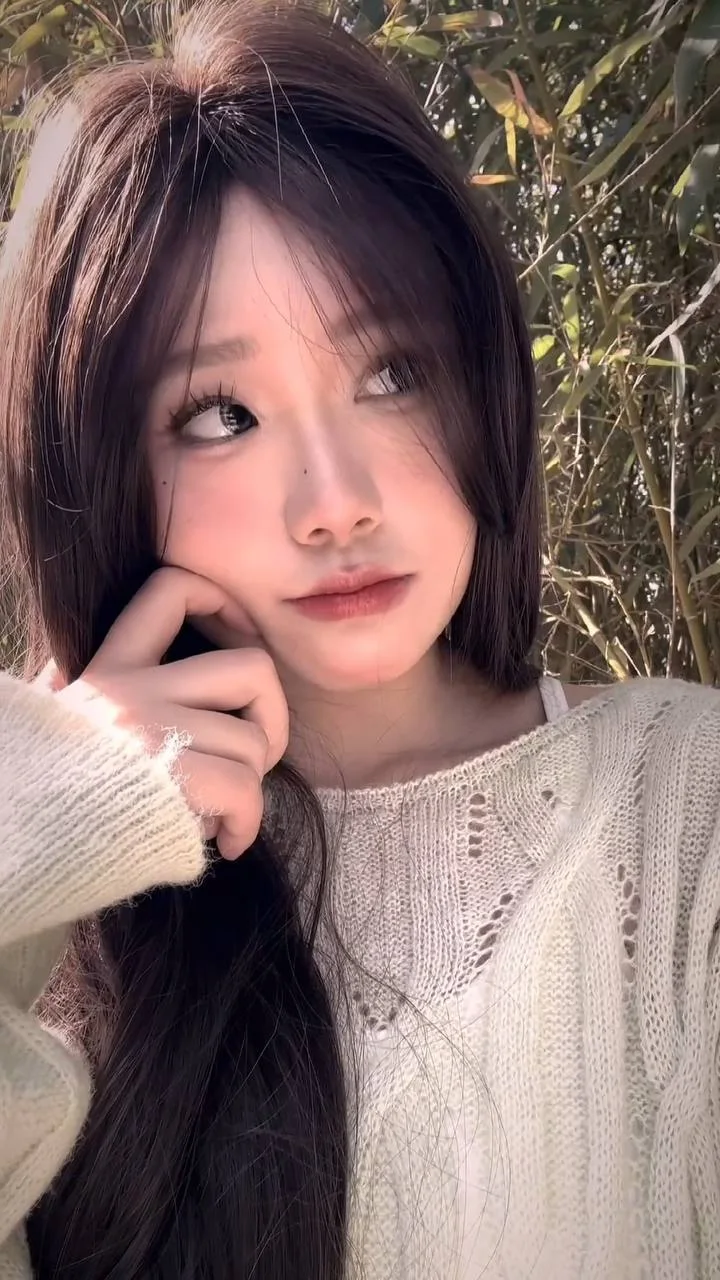 长发女生手托脸颊望向右侧