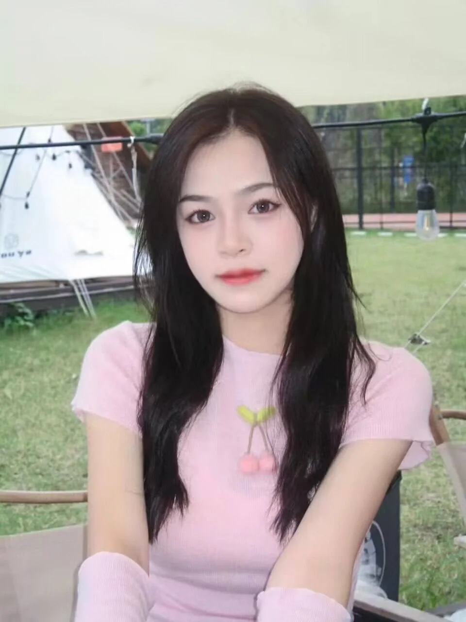 长发女孩坐在草地椅子上