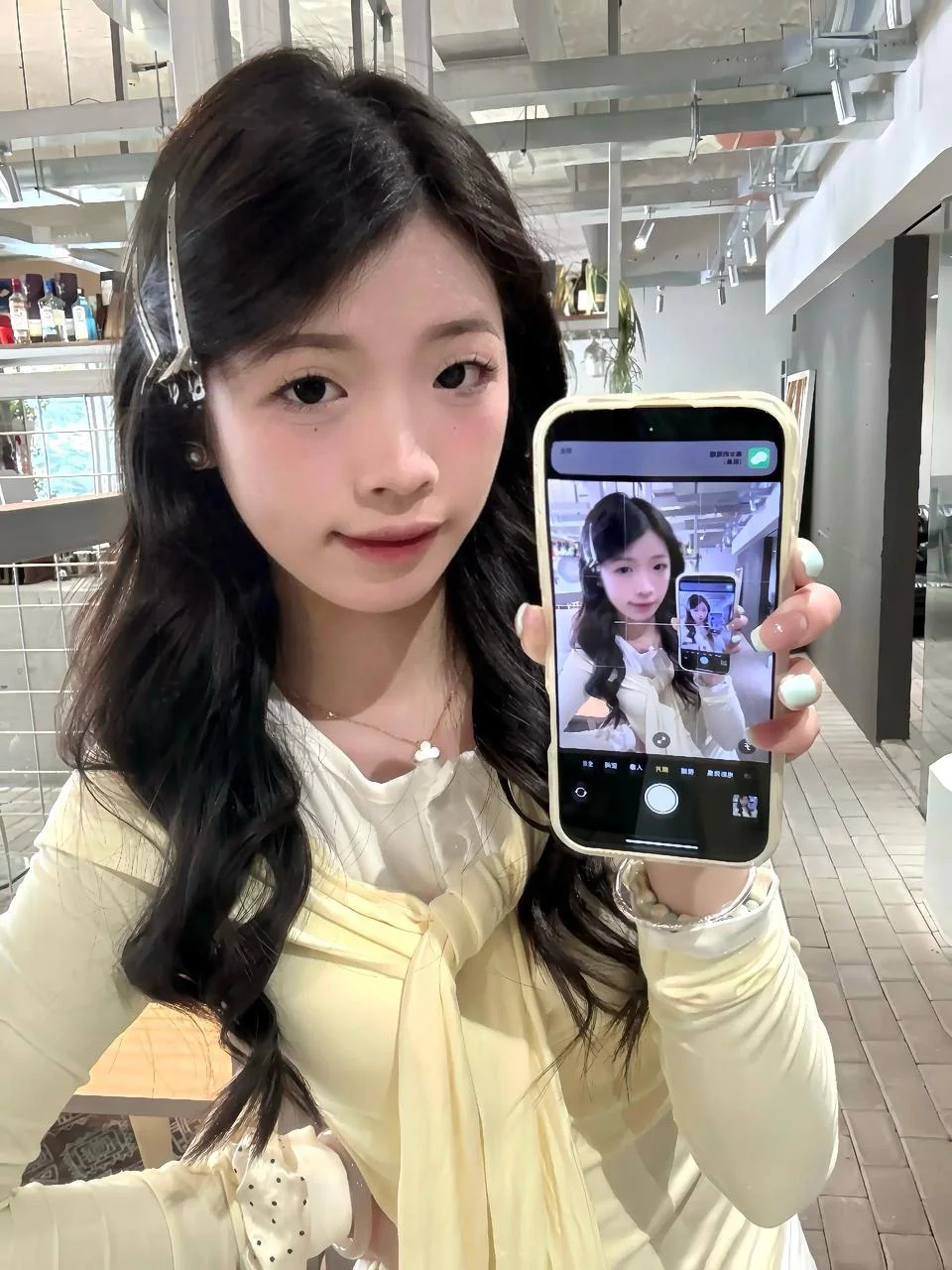 女生举手机自拍，屏幕里显示递归自拍