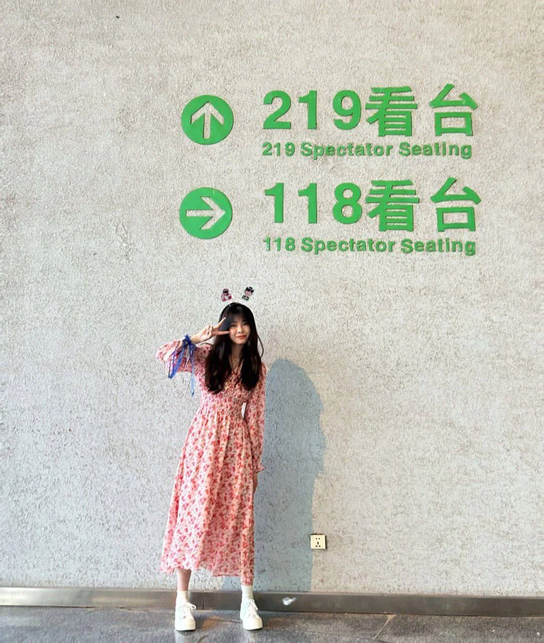 女孩在墙边比剪刀手
