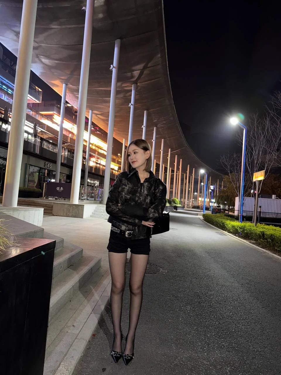 夜里商场外台阶上站着女孩