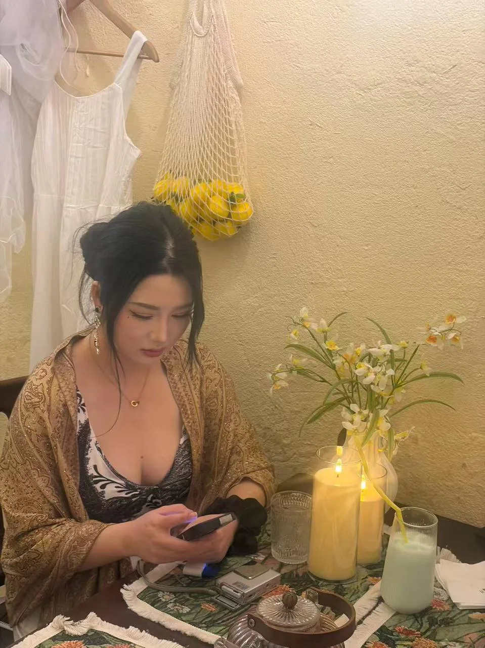 女子低头玩手机 桌上点着三根蜡烛