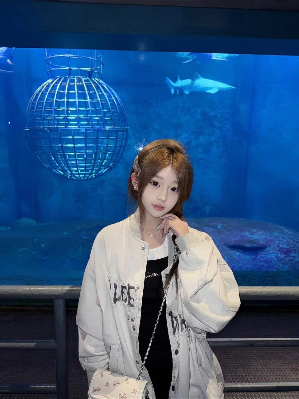 水族馆鲨鱼缸前 白夹克女孩摸脸