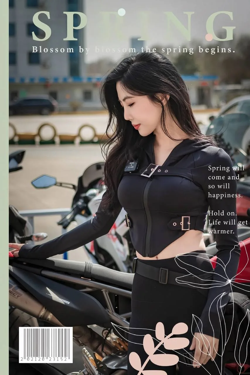 黑发女子手扶摩托车低头看左侧