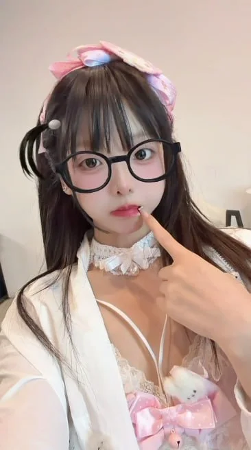 戴黑框眼镜女孩指着嘴唇