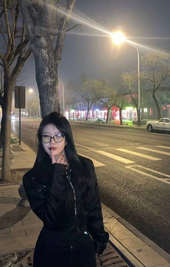 女生路灯下比出嘘的手势