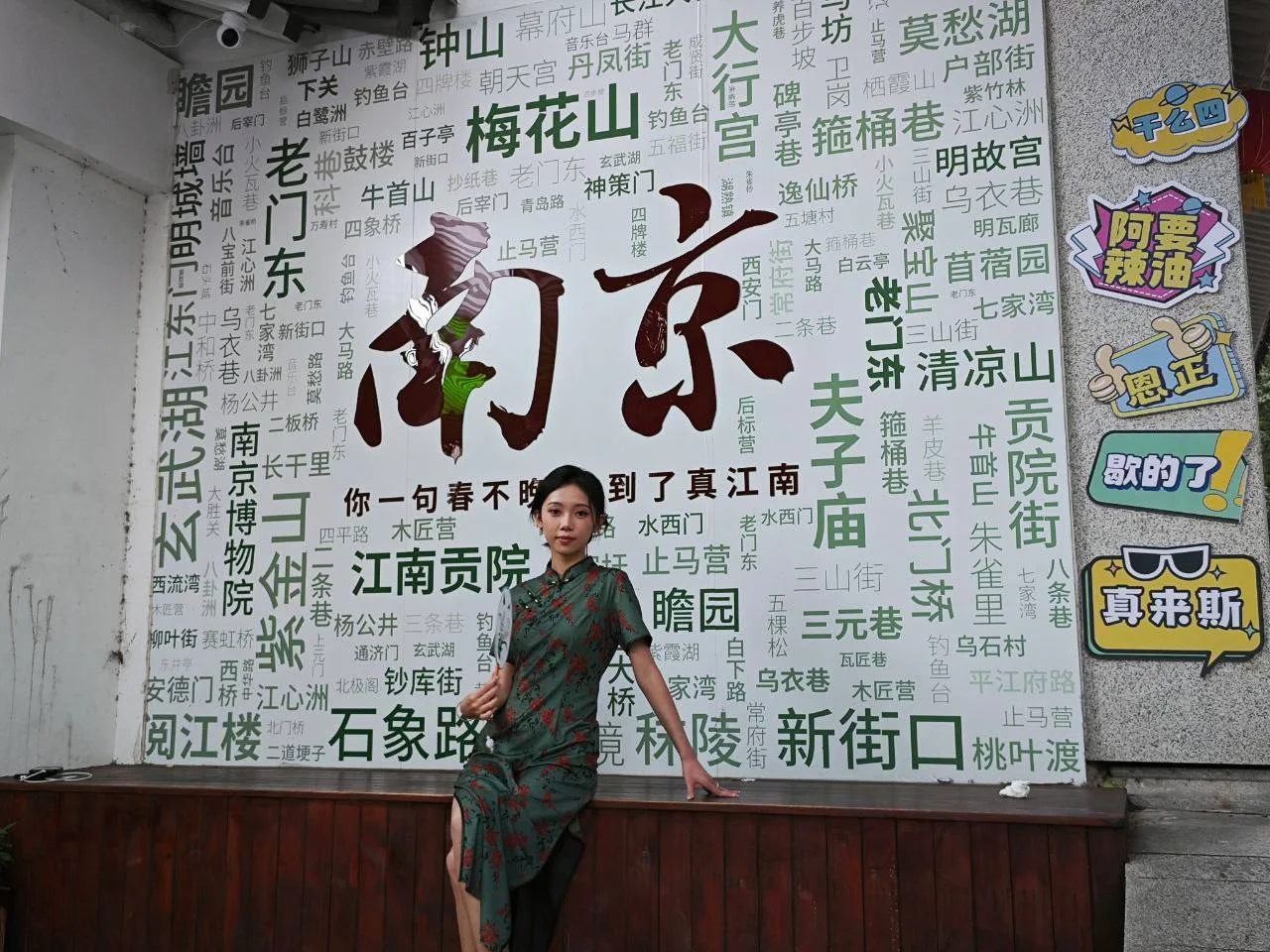 南京墙上贴满地名 女孩穿旗袍站姿