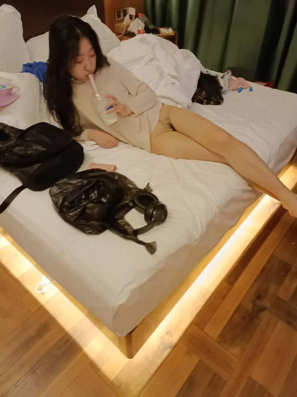 酒店床上吸饮料的女子