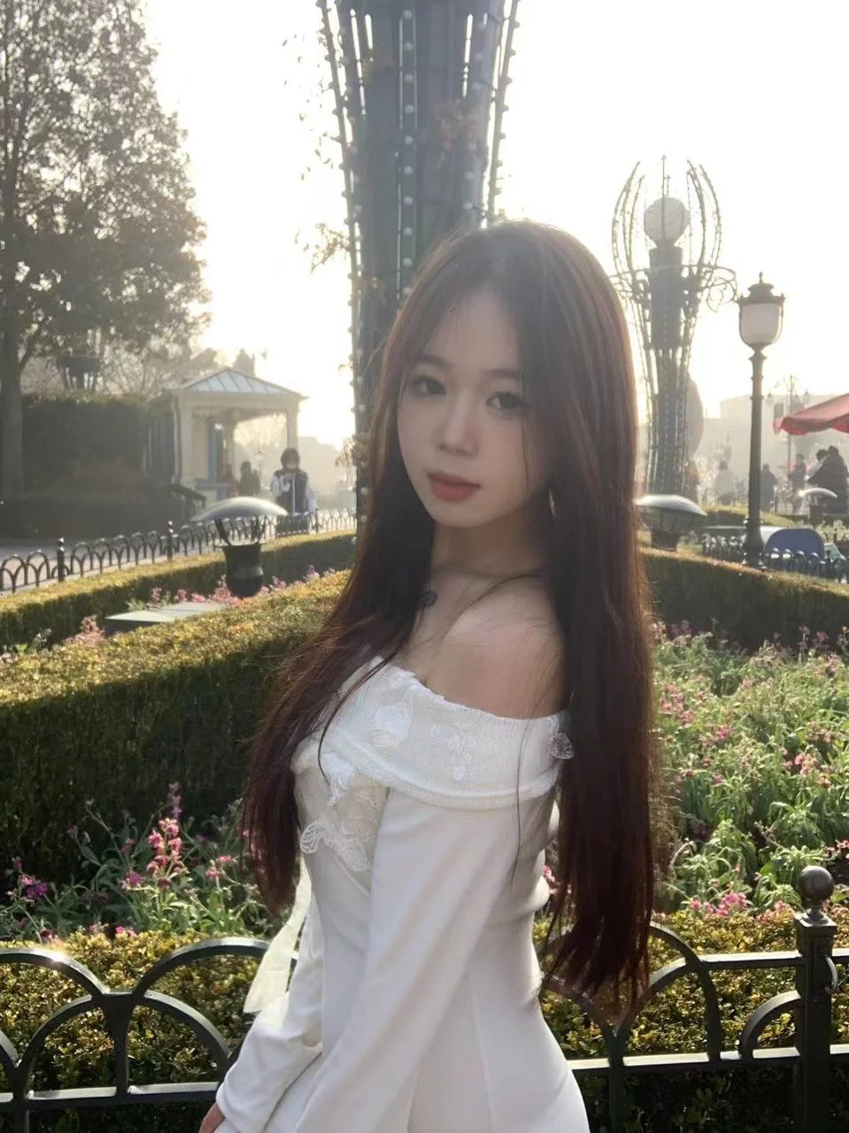 长发女孩站在公园花坛前