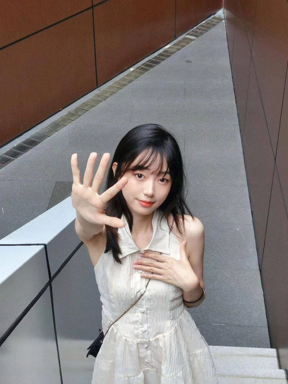 白裙女孩在楼梯上比剪刀手